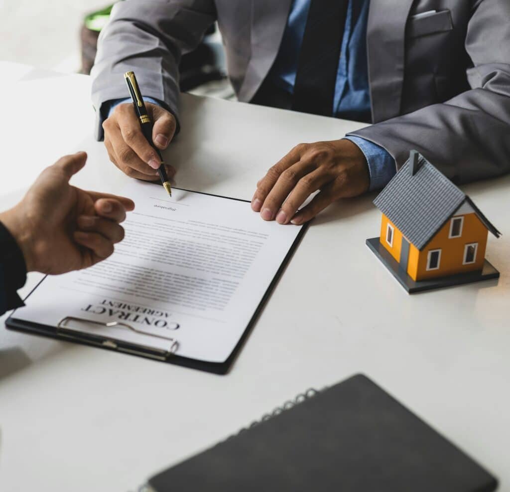 Businessman signing a contract agreement, mortgage, rent, lease, home insurance.